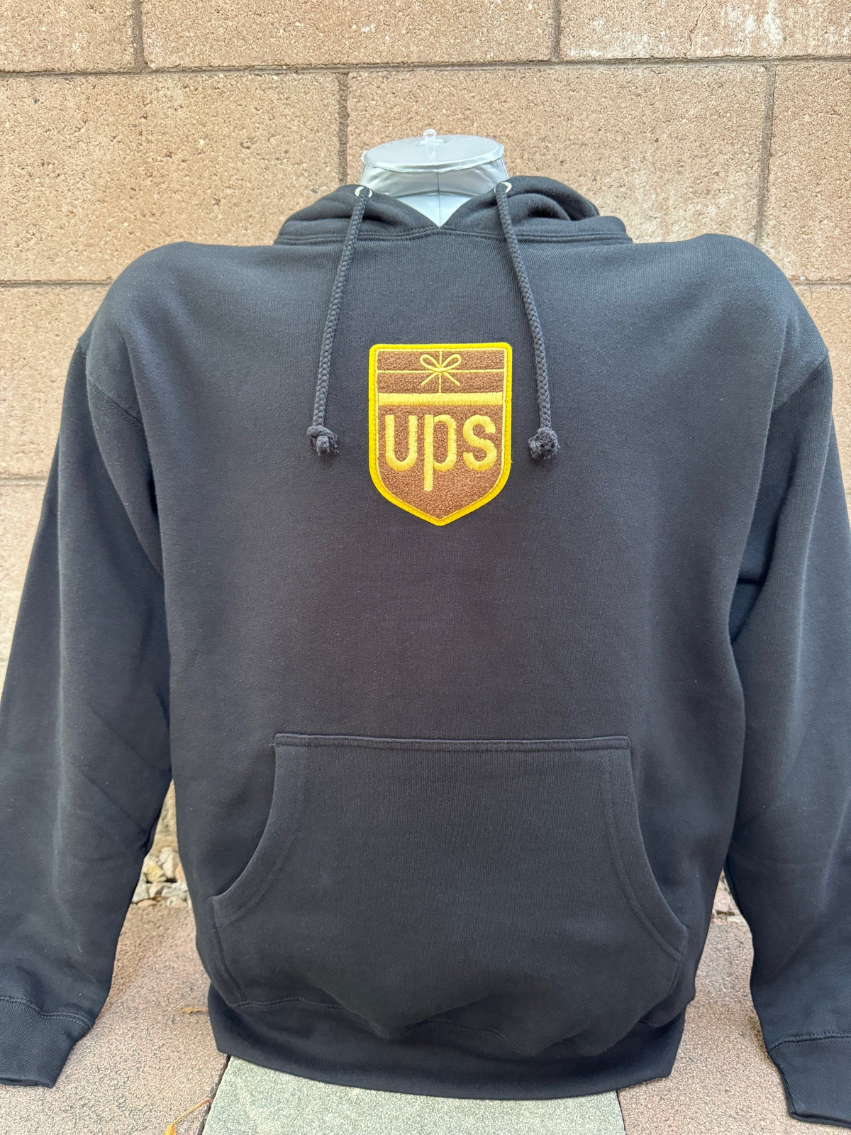 Black hoodie with retro UPS chenille patch logo centered on front