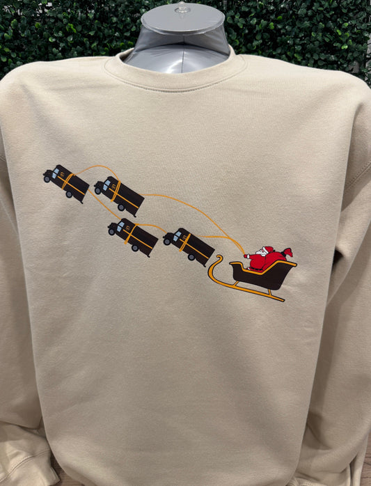 UPS Santa Peak Season beige crewneck sweater with graphic of Santa pulled by UPS trucks