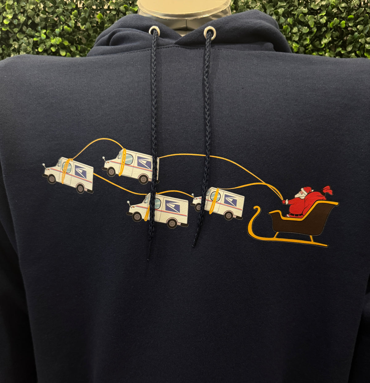 Navy blue hoodie with printed design of Santa being pulled by USPS trucks with logos. USPS Sweatshirt Hooded Hoodie