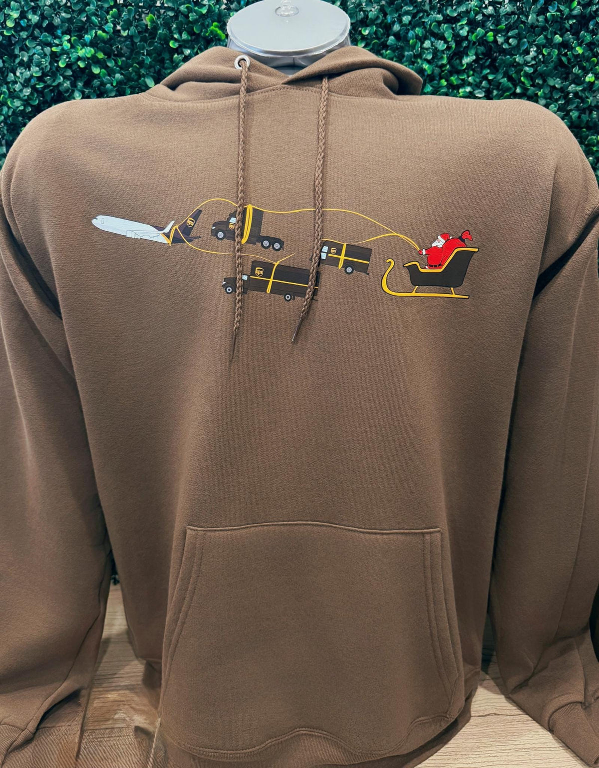 Brown UPS Christmas hoodie with Santa sleigh pulled by UPS trucks and airplane